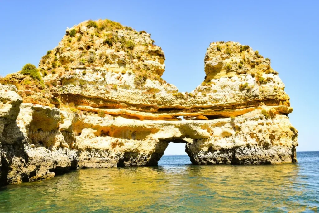 brown rock formation on body of water during daytime