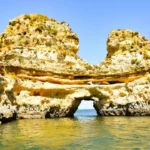 brown rock formation on body of water during daytime