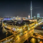 time-lapse photography of vehicle at the road in between the building at nighttime aerial photography