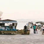 people standing near dock and store during daytime