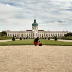 a person sitting on a bench in front of a large building