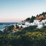 white buildings on mountain by the sea during daytime